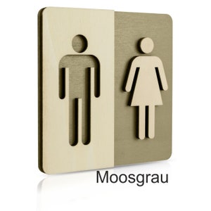 Puede incluir: Un letrero de madera con un s&iacute;mbolo masculino y femenino recortado. El letrero est&aacute; dividido en dos, con el s&iacute;mbolo masculino a la izquierda y el s&iacute;mbolo femenino a la derecha. El lado izquierdo es de color madera claro, y el lado derecho es de color verde oscuro. El letrero dice "Moosgrau" en la parte inferior.