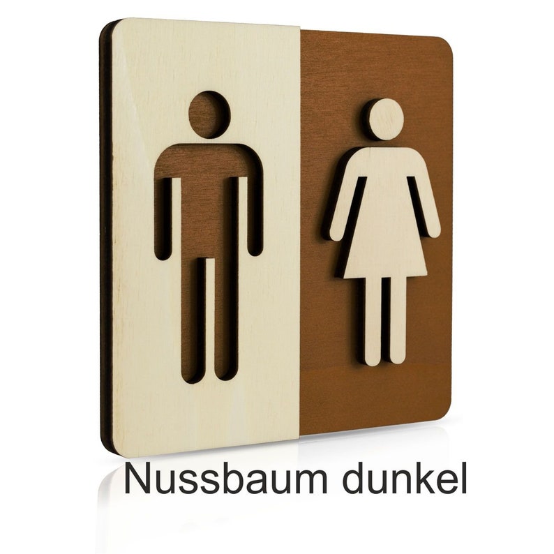 Puede incluir: Un letrero de madera con un s&iacute;mbolo masculino y femenino, separados por una l&iacute;nea vertical. El lado izquierdo es de madera clara y el lado derecho de madera oscura. El texto "Nussbaum dunkel" est&aacute; impreso debajo del letrero.
