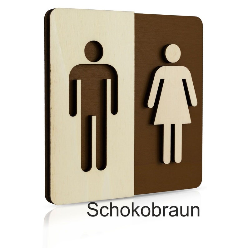 Puede incluir: Un letrero de madera con un s&iacute;mbolo masculino y un s&iacute;mbolo femenino, separados por una l&iacute;nea vertical. El s&iacute;mbolo masculino est&aacute; a la izquierda y el s&iacute;mbolo femenino a la derecha. El letrero est&aacute; pintado en dos colores: madera clara a la izquierda y marr&oacute;n oscuro a la derecha. El texto "Schokobraun" est&aacute; impreso debajo del letrero.