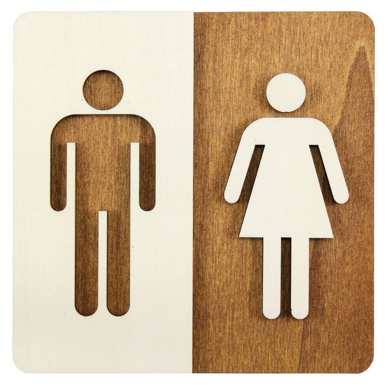 Puede incluir: Un letrero de madera con fondo blanco y fondo marr&oacute;n. El letrero tiene dos s&iacute;mbolos, uno a cada lado. El s&iacute;mbolo de la izquierda es una figura masculina estilizada. El s&iacute;mbolo de la derecha es una figura femenina estilizada.