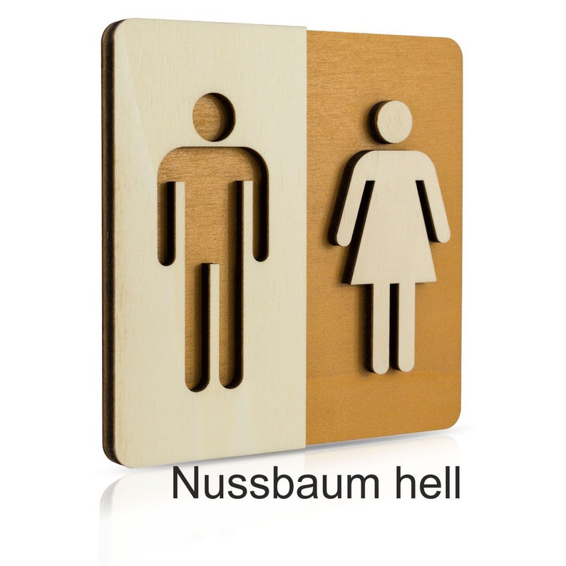 Puede incluir: Un letrero de madera con un s&iacute;mbolo masculino y femenino recortado. El letrero est&aacute; dividido en dos, con el s&iacute;mbolo masculino a la izquierda y el s&iacute;mbolo femenino a la derecha. El lado izquierdo es de madera clara y el lado derecho es de madera m&aacute;s oscura. El letrero dice "Nussbaum hell" en la parte inferior.