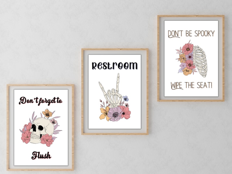 Puede incluir: Tres impresiones enmarcadas con ilustraciones florales y de esqueletos y texto. La primera impresi&oacute;n dice "No olvides tirar de la cadena" con una calavera y flores. La segunda impresi&oacute;n dice "Aseo" con una mano de esqueleto y flores. La tercera impresi&oacute;n dice "No seas espeluznante, &iexcl;limpia el asiento!" con una caja tor&aacute;cica de esqueleto y flores.