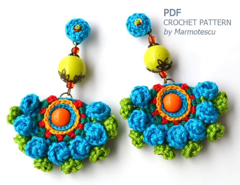 May include: Crochet earrings with a colorful floral design, featuring blue, green, orange, yellow, and red accents. The earrings are adorned with beads and a large, round, yellow bead.