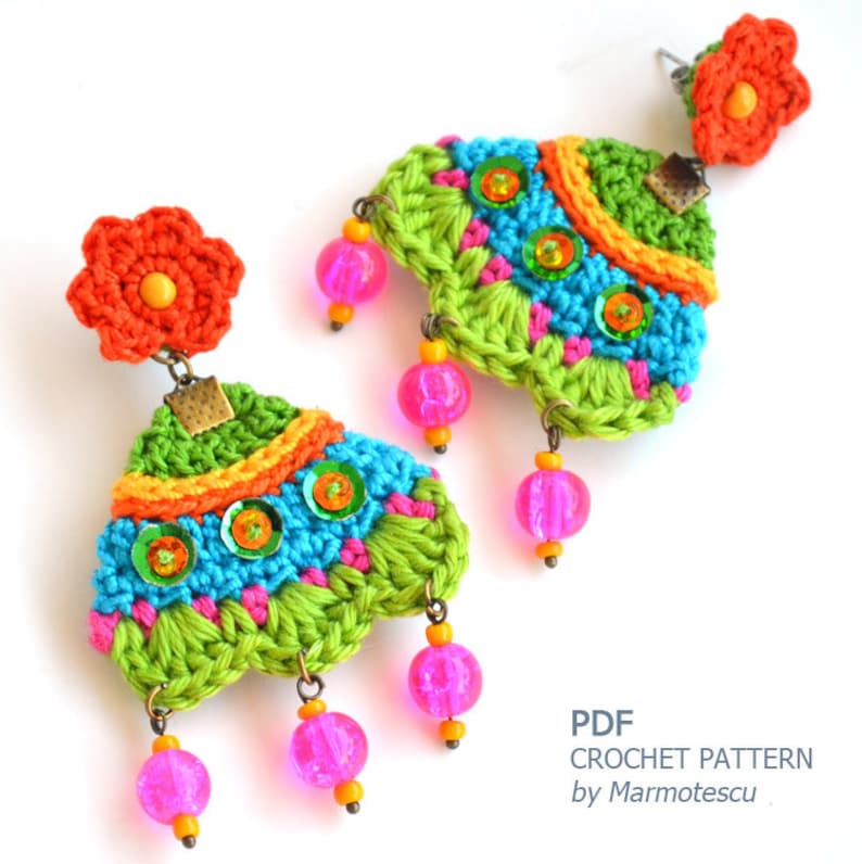 Puede incluir: Un par de pendientes de ganchillo coloridos con cuentas rosas y lentejuelas. Los pendientes tienen forma de tri&aacute;ngulo con una flor en la parte superior. PATR&Oacute;N DE CROCHET PDF por Marmotescu.