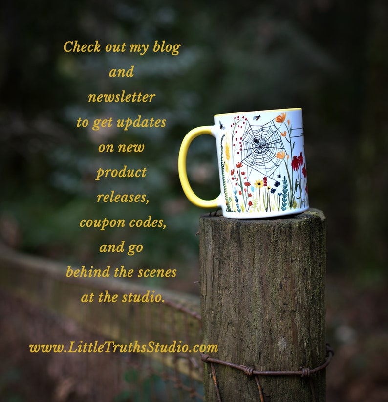 May include: A yellow and white ceramic mug with a floral and spiderweb design. The mug is sitting on a wooden post with a wire fence in the background. The text on the mug reads "Check out my blog and newsletter to get updates on new product releases, coupon codes, and go behind the scenes at the studio. www.LittleTruthsStudio.com"