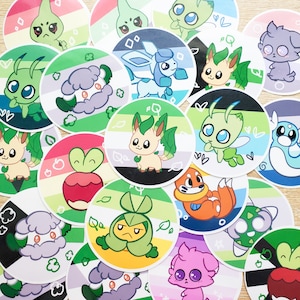 May include: A collection of colorful, round stickers featuring various cartoon creatures. Each sticker has a unique design with vibrant colors, including green, blue, orange, and pink. The stickers are arranged on a light-colored surface, creating a playful and eye-catching display.