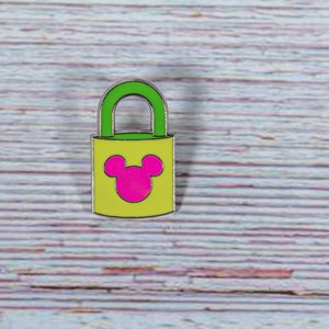 May include: A yellow padlock with a green top and a pink Mickey Mouse head design.