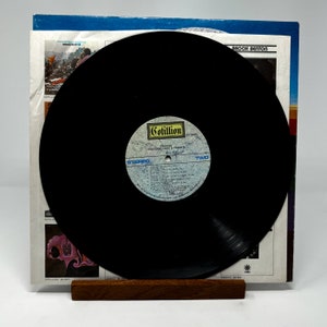 Puede incluir: Un disco de vinilo negro con una etiqueta blanca. La etiqueta tiene el texto "Cotillion" y "Emotional Lace & Palmer" impreso en ella. El disco est&aacute; en un soporte de madera y es parte de un &aacute;lbum de discos.