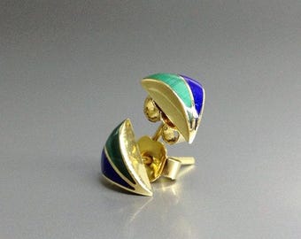 Può includere: Un paio di orecchini a lobo con un design triangolare curvo e bordi in metallo dorato. Ogni orecchino presenta un intarsio diviso in malachite verde vibrante e lapislazzuli blu intenso, fissato con un perno standard e una chiusura a farfalla.