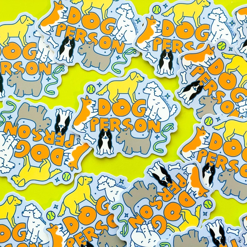 May include: A collection of colorful stickers featuring various dog breeds and the text "Dog Person" in a playful, cartoon style. The stickers are on a bright yellow background.