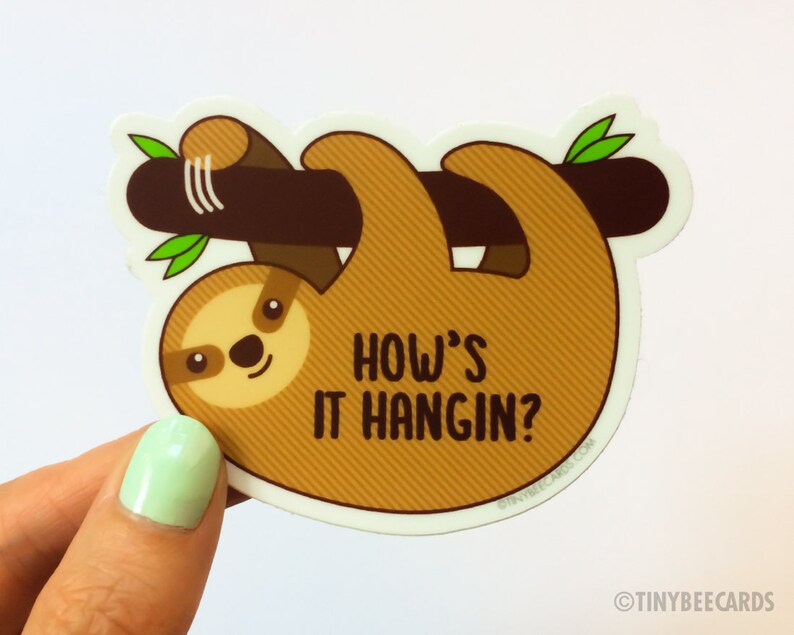 May include: A brown sloth hanging upside down from a branch with green leaves. The sloth has a cute face and the text "How's it hangin?" is written below it.