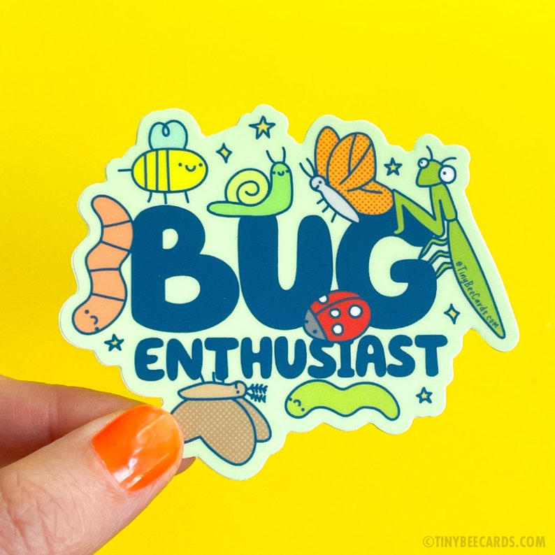 Peut inclure: Un autocollant vert clair avec les mots "BUG ENTHUSIAST" en lettres bleues. L'autocollant est d&eacute;cor&eacute; de divers insectes de bande dessin&eacute;e color&eacute;s, notamment une abeille, un escargot, un papillon, une coccinelle, un ver et une mante religieuse.