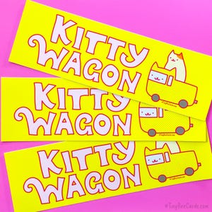 Pode incluir: Tr&ecirc;s autocolantes amarelos com as palavras "KITTY WAGON" numa fonte caprichosa. Cada autocolante apresenta um gato de desenho animado numa carruagem amarela. Os autocolantes est&atilde;o num fundo rosa.