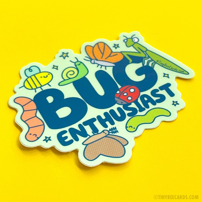 Peut inclure: Un autocollant vert clair avec le texte "BUG ENTHUSIAST" en lettres bleues. L'autocollant est entour&eacute; d'insectes de dessin anim&eacute;, dont une abeille, un escargot, une coccinelle, un ver, un papillon et une mante religieuse.