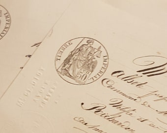 May include: A close-up of a vintage stamp featuring a woman holding scales and a sword. The stamp is circular and has the text "TIMBRE" and "IMPERIAL" around the edge. The year "1911" is visible in the centre of the stamp.