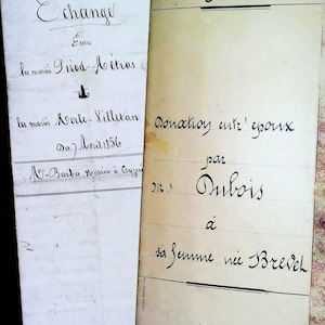 Könnte beinhalten: Zwei antike französische Rechtsdokumente mit handschriftlichem Text in schwarzer Tinte auf cremefarbenem Papier. Das linke Dokument ist mit Echange betitelt und auf 1905 datiert, das rechte mit Donation entre epoux und 9. Januar 1908.
