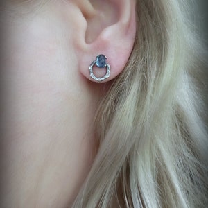 Peut inclure: Boucles d'oreilles en argent avec un petit cabochon bleu ovale serti dans un design de fil torsad&eacute;.
