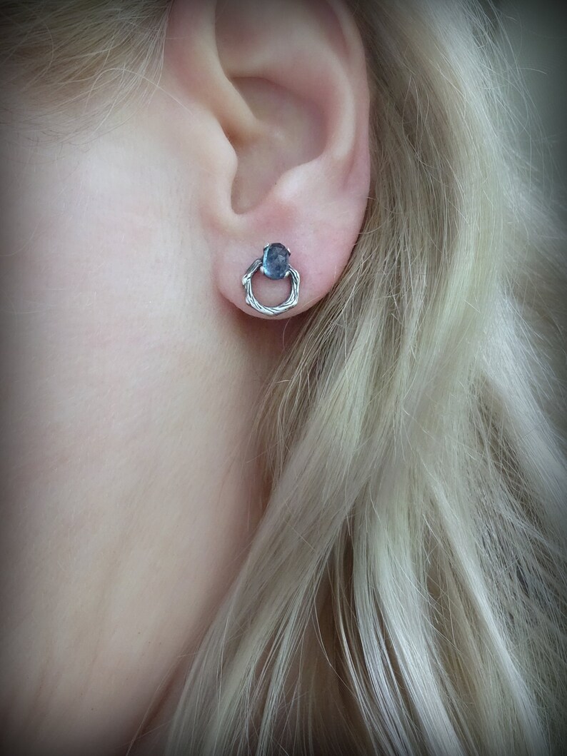 Peut inclure: Boucles d'oreilles en argent avec un petit cabochon bleu ovale serti dans un design de fil torsad&eacute;.
