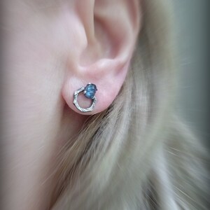 Peut inclure: Boucles d'oreilles en argent avec une pierre pr&eacute;cieuse bleue sertie dans un design de fil torsad&eacute;.