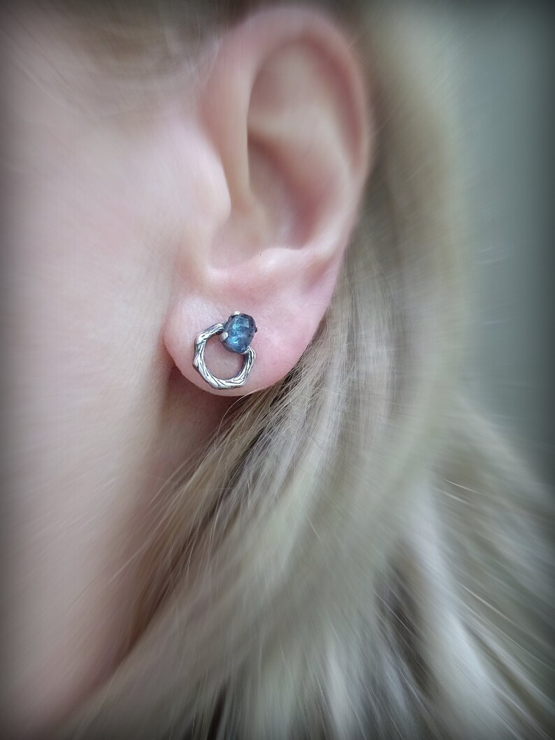 Peut inclure: Boucles d'oreilles en argent avec une pierre pr&eacute;cieuse bleue sertie dans un design de fil torsad&eacute;.