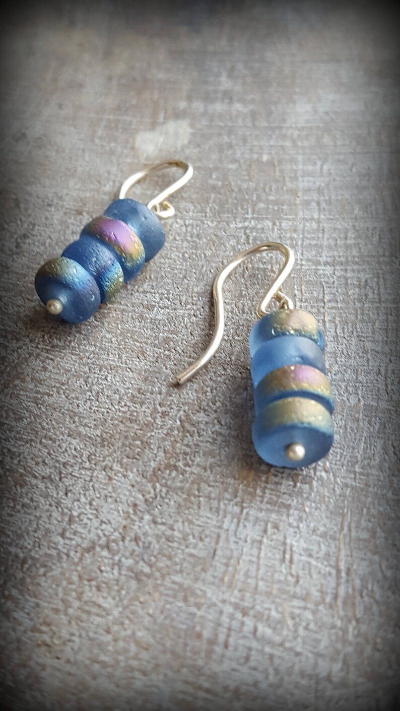 May include: A pair of blue and gold glass bead earrings with silver hooks.