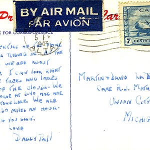 May include: Vintage postcard with a blue "By Air Mail" stamp and a Canadian stamp. Handwritten message in blue ink describes a flight over trees and lakes. The postcard is addressed to Martin and David in Michigan.