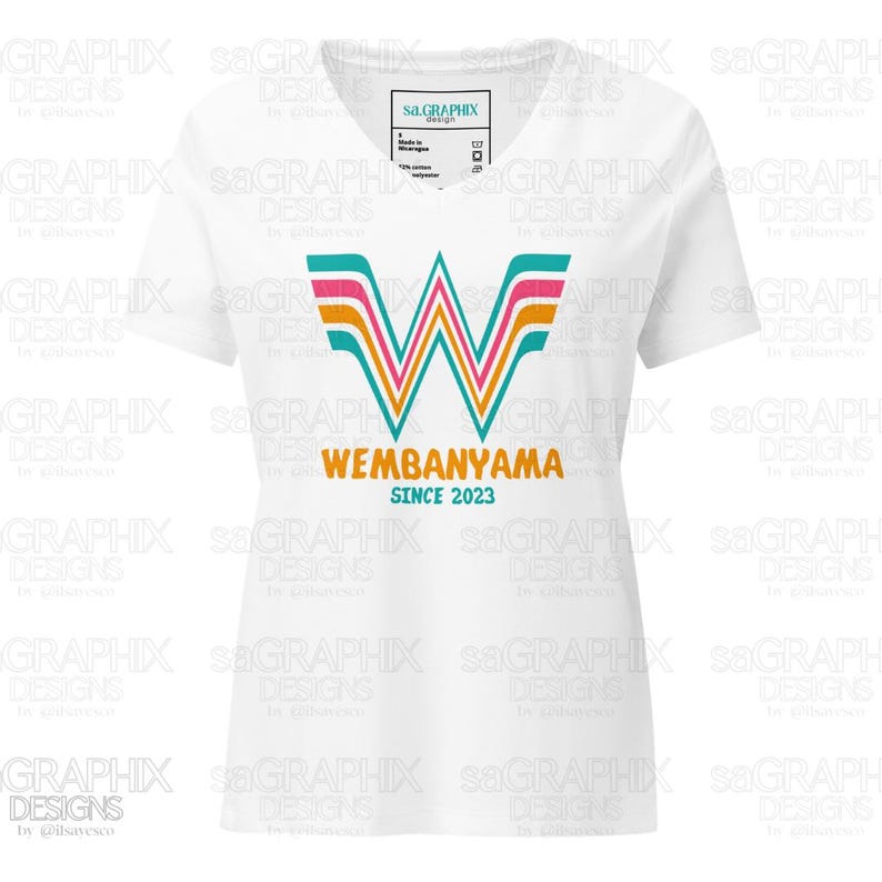 Puede incluir: Camiseta blanca con cuello en V con un dise&ntilde;o gr&aacute;fico colorido. El dise&ntilde;o incluye la palabra "WEMBANYAMA" y el texto "SINCE 2023", utilizando colores turquesa, rosa y naranja. La camiseta tiene una etiqueta que dice "sa.GRAPHIX".
