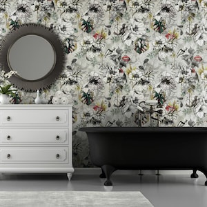 May include: A white bathroom with a black clawfoot bathtub, a white dresser with three drawers, and a round mirror with a black frame. The walls are covered in a floral wallpaper with a white background and black, red, and green floral designs.