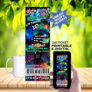 Può includere: Un invito per una festa di compleanno a tema gaming. L'invito, in formato biglietto 2x6, presenta il testo "GAME ON!! BRANTLEY IS TURNING 10". L'invito include i dettagli dell'evento e un codice a barre. Nell'immagine sono presenti anche una tazza bianca e uno smartphone che mostra l'invito.
