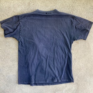 May include: A dark blue t-shirt with short sleeves. The shirt is made of a soft, comfortable fabric.