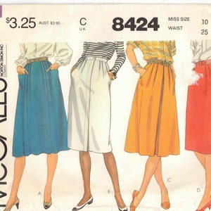 May include: A vintage sewing pattern for a skirt, McCall's pattern number 8424, size 10, waist 25. The pattern shows four different styles of skirts: a blue skirt with pockets, a white skirt with a striped top, an orange skirt with a plaid top, and a red skirt with buttons.