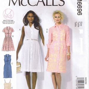 May include: McCall's sewing pattern M6696 featuring various dress designs. The pattern includes options for a white eyelet dress, a floral print dress, a denim dress, and a slip dress. The cover showcases the dress styles on models.