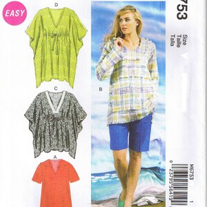May include: Sewing pattern McCall's M6753 for a tunic top and shorts. The pattern includes three different styles: a green tunic with a tie, a gray tunic with a tie, and a red tunic with a collar. The model is wearing a plaid tunic top and blue shorts.