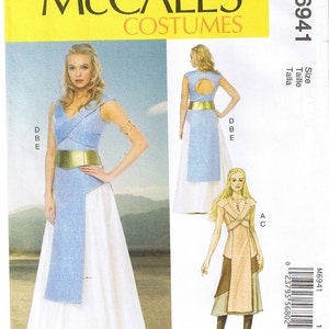 May include: McCall's Costumes sewing pattern M6941. The pattern features a woman in a light blue and white dress with a gold belt and arm cuff. The pattern also shows a drawing of a second costume.