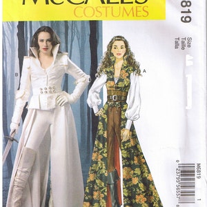 Può includere: Un modello di cucito McCall's Costumes, M6819, con due modelli di costumi. Uno è un completo bianco con un cappotto lungo, pantaloni e stivali alti. L'altro è un gilet e una gonna a fantasia floreale su una tuta marrone, con stivali alti.