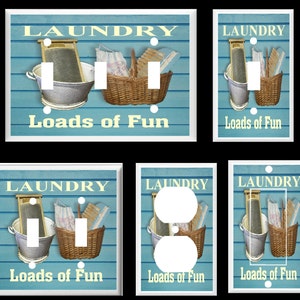May include: Set of six light switch and outlet covers featuring a vintage laundry room design. The covers are white with a blue background and feature a washboard, a bucket, and a basket. The text "Laundry Loads of Fun" is printed on each cover.