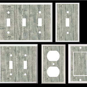 May include: Set of five light switch and outlet covers featuring a wood grain pattern in shades of gray and white. The covers are designed to look like weathered wood planks.