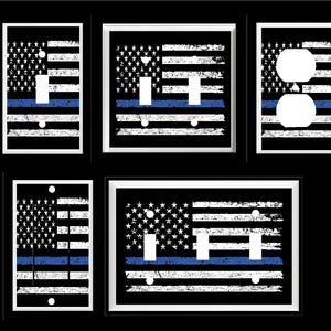 May include: A collection of light switch and outlet covers featuring a distressed American flag design with a blue stripe. The covers are black, white, and blue, with various configurations for switches and outlets.