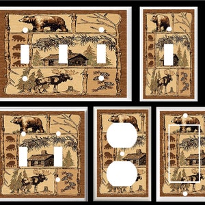 May include: Set of six light switch and outlet covers featuring a woodland scene with bears, moose, and cabins. The covers are printed on a beige background with brown accents.