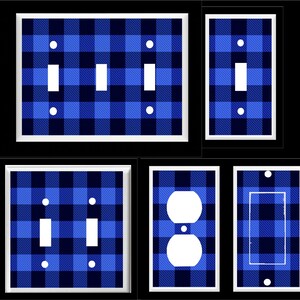 May include: A collection of blue and navy plaid light switch covers and outlet covers. The covers have a white border and are in various configurations, including single, double, and triple switch plates, and a double outlet cover.
