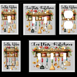 May include: Four white light switch covers with a gray background. Each cover features a colorful illustration of a kitchen shelf with jars, utensils, and flowers. The text "In this Kitchen We Make Messes & Memories" is printed on the covers.