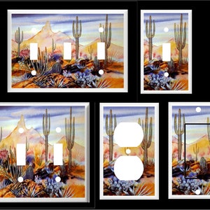 May include: A set of decorative light switch and outlet covers featuring a watercolor painting of a desert landscape with tall cacti and a mountain range in the background. The colors are vibrant and include shades of blue, purple, orange, and yellow.