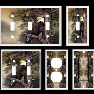 May include: Set of six light switch and outlet covers featuring a bald eagle perched on a branch in a forest setting. The covers are white with a glossy finish.
