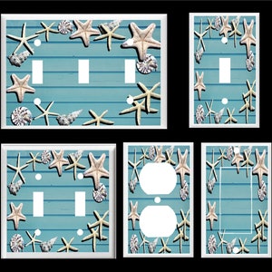 May include: Set of six light switch and outlet covers featuring a beach theme with white starfish and seashells on a blue and white striped background.