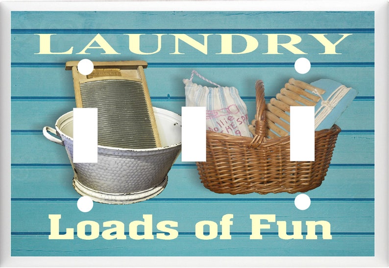 May include: A light blue wooden light switch cover with a vintage laundry theme. The cover features a washboard, a basket of clothes, and the text "Laundry Loads of Fun".