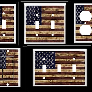 May include: Set of five light switch and outlet covers featuring a distressed wood American flag design. The flag is red, white, and blue with a faded wood grain texture.