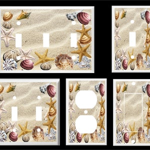May include: Set of six decorative light switch and outlet covers featuring a beach scene with seashells, starfish, and sand. The covers are white with a beige background.