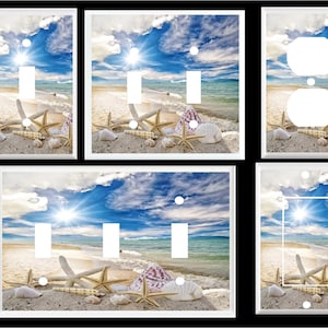 May include: A set of four light switch and outlet covers featuring a beach scene with blue sky, white clouds, a bright sun, and seashells on the sand.