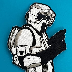 Op de afbeelding: Witte geborduurde patch van een Star Wars Snowtrooper die een blastergeweer vasthoudt. De patch is op een blauwe achtergrond.