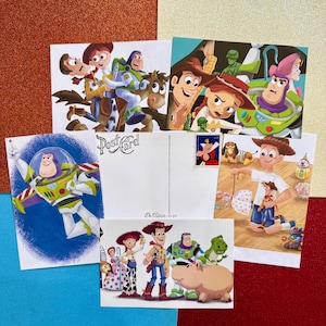 May include: A collection of colorful postcards featuring characters from the animated movie Toy Story. The postcards showcase various scenes and characters, including Woody, Buzz Lightyear, and Jessie, with vibrant illustrations.
